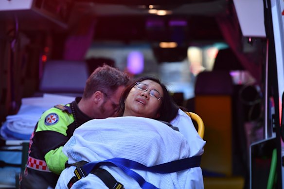 A woman is put into an ambulance outside Hotel CBD at the corner of King and York streets in Sydney.