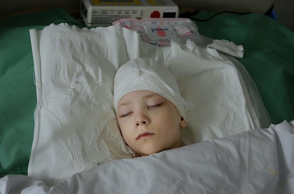Volodymyr Baklanov, 7, lies in intensive care from a bullet wound at Kharkiv No 4 Emergency Hospital.  Volodymyr was driving with his mum and younger brother Viktor when they were shot at, his mum was killed in the attack. Kharkiv, Ukraine. 
