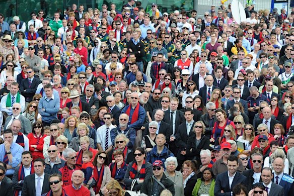 Crowds gather at Federation Sqaure to watch large screens depicting the funeral service.