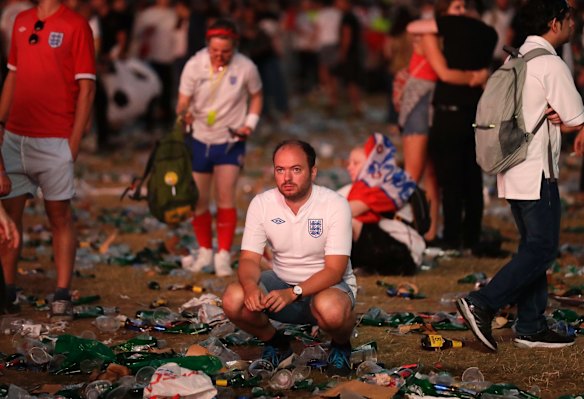 England soccer fans react after losing the semifinal match between Croatia and England at the 2018 soccer World Cup, in Hyde Park, London.