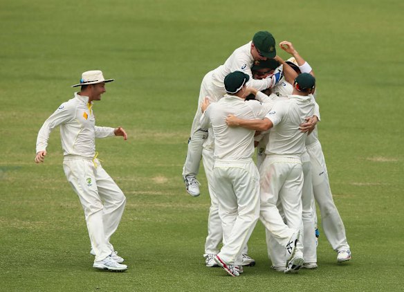 Mitchell Johnson of Australia celebrates with Chris Rogers after they combined to dismiss Tim Bresnan of England during day five of the Third Ashes Test Match.