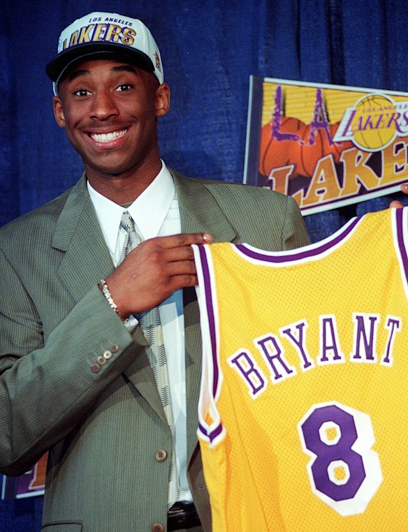 1996: Kobe Bryant, 17, jokes with the media as he holds his Los Angeles Lakers jersey during a news conference at the Great Western Forum in Inglewood, California.