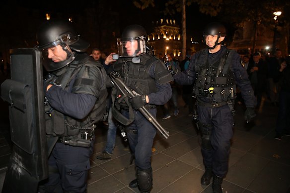 Police armed with a shotgun and a ballistics shield react to suspicious behavior at Place de la Republique in Paris on Sunday 15 November.