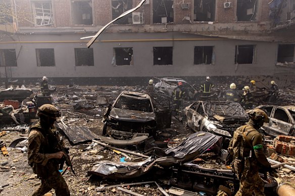  Members of the Ukrainian military walk amid debris as firefighters work to extinguish a fire after a shopping center was hit by a Russian missile strike in Kharkiv, Ukraine. 