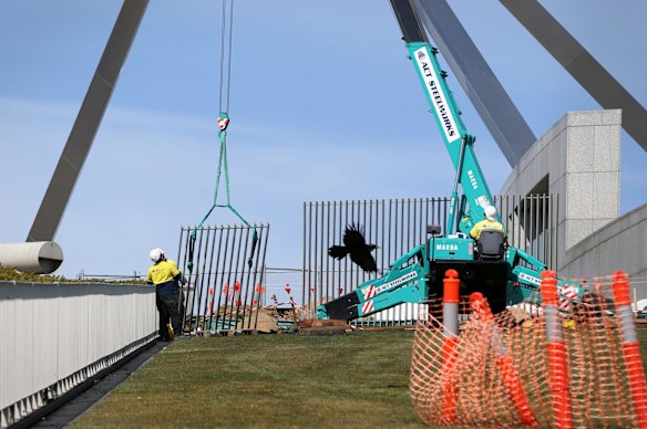 A security fence is installed across the lawns of Parliament House.