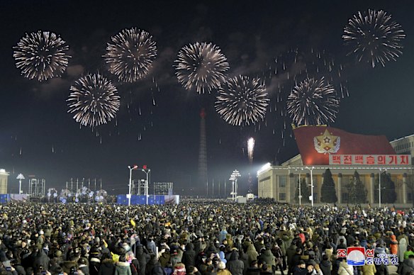 Fireworks illuminate the night sky, marking the New Year, as crowds of people look on, at Kim Il Sung Square in Pyongyang, North Korea.