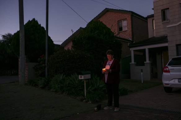 Wendy Moran stands on her driveway to commemorate ANZAC Day in Ryde.