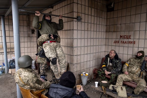 A member of a Territorial Defence unit does pull-ups before starting his shift guarding a barricade on the outskirts of eastern Kyiv.