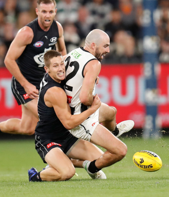 Steele Sidebottom is tackled by Lachie Fogarty.