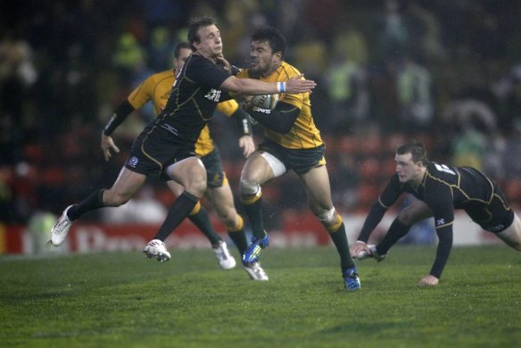 Scottish player Tom Brown, tries to tackle Wallaby Digby Ioane.