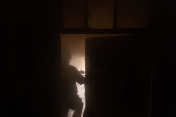 A police officer tries to extinguish a fire in an apartment after a Russian rocket attack hit a residential building in Kharkiv, Ukraine.