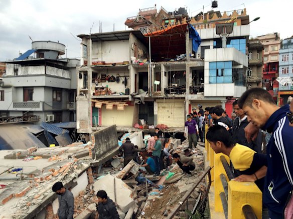 People survey a site damaged by an earthquake, in Kathmandu, Nepal.