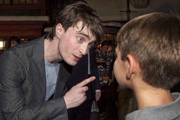 Daniel Radcliffe talks with a young fan at the grand opening celebration for The Wizarding World of Harry Potter at the Universal Studio Resort in Orlando, Florida.