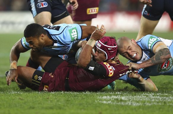 Johnathan Thurston of the Maroons is tackled by David Klemmer of the Blues.