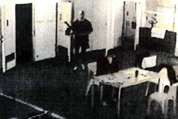 Prison CCTV captures the moment Johnson ambushes Carl Williams, who was reading a newspaper before he was fatally bashed. Johnson would later drag his body to his cell.