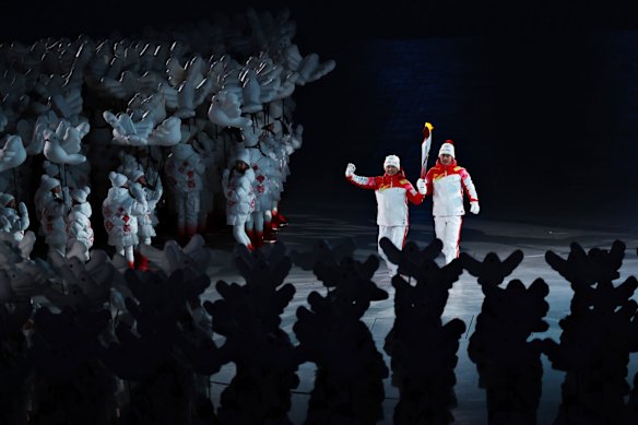 Torch bearers Dinigeer Yilamujiang and Jiawen Zhao of Team China hold the Olympic flame.