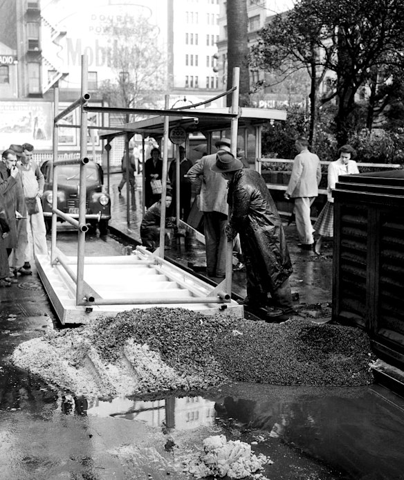 A new bus shelter is erected in Carrington Street, Wynyard, Sydney on 27 June 1958 during the changeover from trams to buses. 