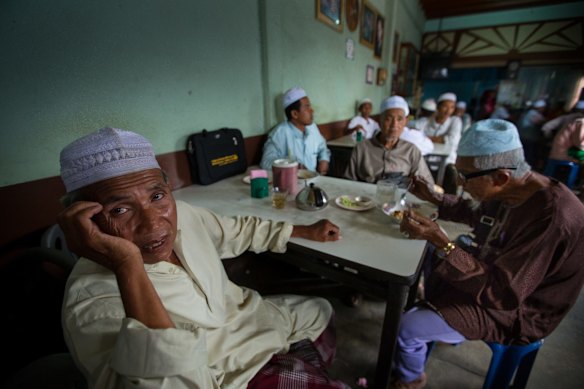 Pattani, Thailand. Muslim men gather to talk in a cafe near the mosque in Yala, Southern Thailand. Ninety per cent of the population in this area are ethnic Malays.
