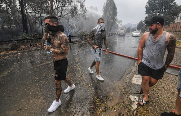 Local residents Mark Bosa and Tori Wissell and a friend helping to put out spot fires with bottles of water.