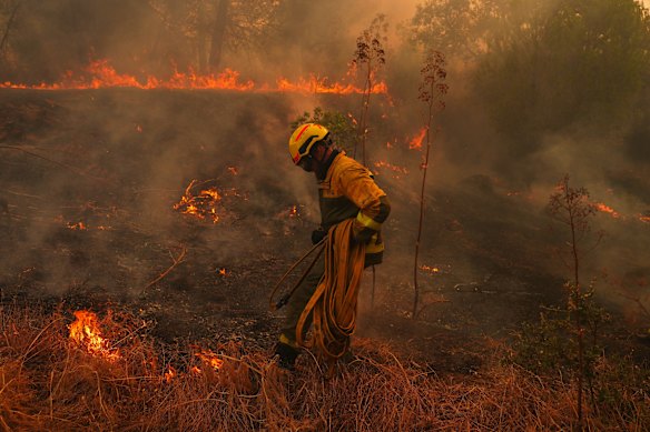 Un vigile del fuoco doma domenica un incendio a San Martin de Valdeiglesias, a ovest di Madrid, in Spagna.