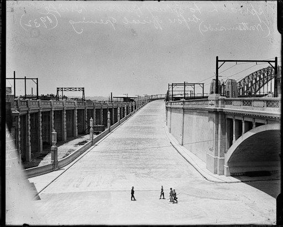 Four men on the northern road approaching Sydney Harbour Bridge before its opening in 1932.