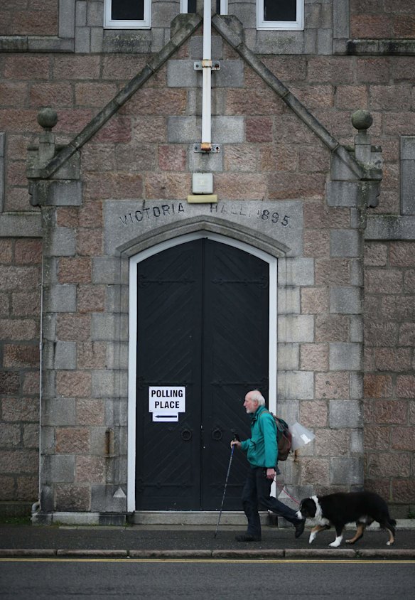 A man walks to Victoria Hall to cast his vote at the nearest polling station to Balmoral Castle, summer home to Queen Elizabeth II in Ballater, Scotland.