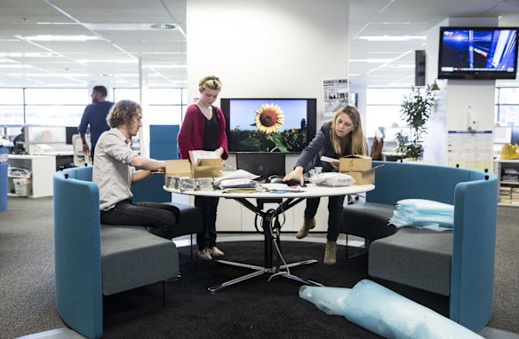 Fairfax photographer Kate Geraghty (right) , and SMH News desk staff Charlie Falkner (left) and SMH intern Kate Reid (2nd from left) in teh SMH Newsroom packaging up Sunflower seeds to be sent to victims families of the MH17 crash.