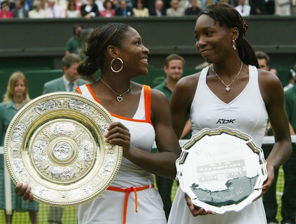 2003 Wimbledon - Serena Williams, left, holds her trophy, as she looks over at her sister Venus, after defeating her in the Women's Singles final.