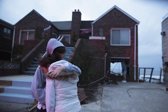 Rachel Deoadato and Elizabeth Denino hug in front of their their aunt's house of 25 years, destroyed by rising waters from last night's storm surge due to Hurricane Sandy in Seagate Association, a gated community in New York, October 30, 2012.