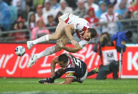 The Dragons Brett Morris goes flying over the Roosters Sam Perrett.