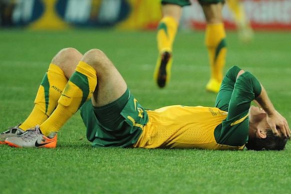 Luke Wilkshire lies on the ground after Australia were knocked out.