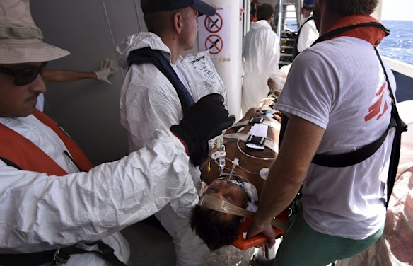 An unconscious refugee is evacuated from the MY Phoenix by Medecins Sans Frontieres medical staff and Migrant Offshore Aid Station crew to Italian warship then taken to Italy.