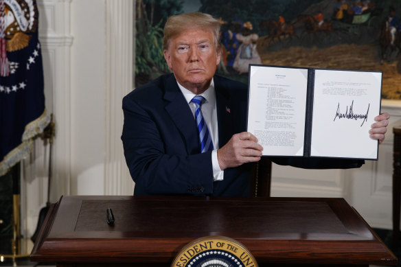 President Donald Trump shows a signed memorandum confirming the US withdrawal from the Iran nuclear deal.