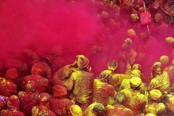Indian Hindu devotees throw coloured powder at the Radha Rani temple in Barsana, India.