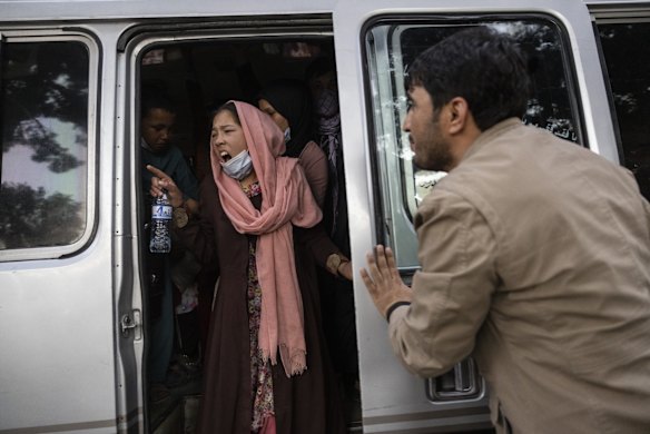 A woman yells for her family to hurry up as displaced Afghans from the northern provinces are evacuated from a makeshift IDP camp in Share-e-Naw park on August 12, 2021 in Kabul, Afghanistan. People displaced by the Taliban advancing are flooding into the Kabul capital to escape the Taliban takeover of their provinces.