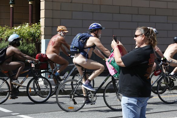 A member of the public takes a photo of the cyclists as they turn on to Gertrude Street.