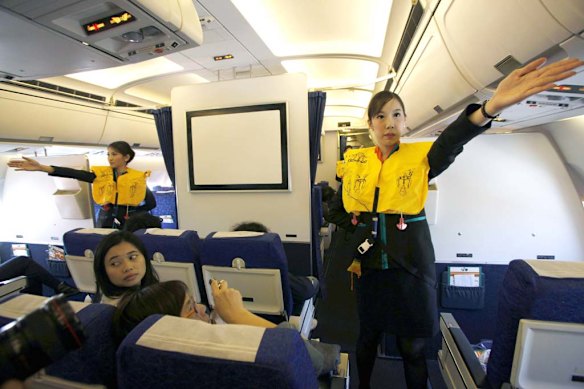PC Air transsexual flight attendant Chayathisa Nakmai (R), 24, demonstrates in-flight safety to passengers.