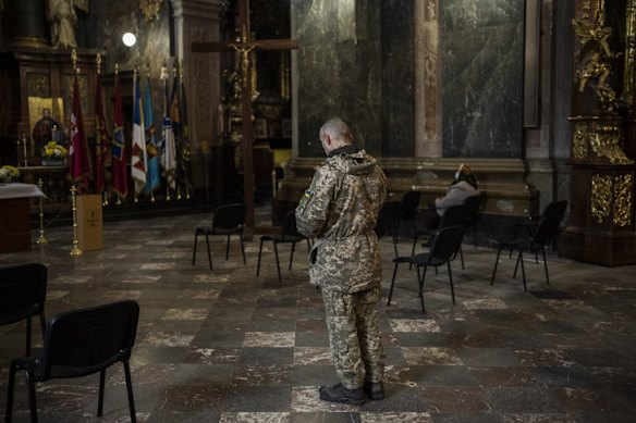 A Ukrainian soldier prays inside the Saints Peter and Paul Garrison Church in Lviv.