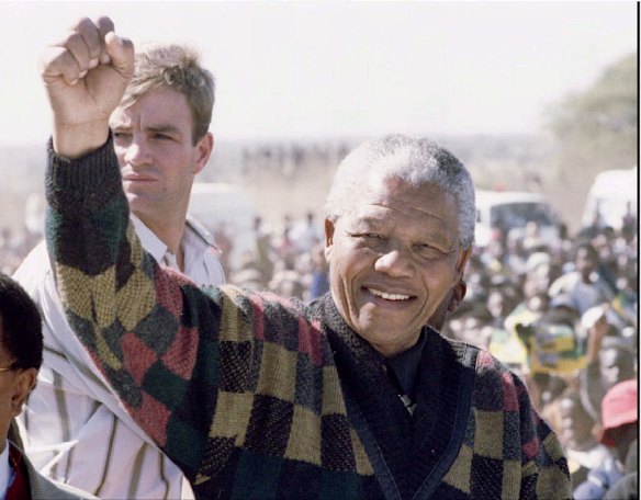 NELSON MANDELA.  salutes the crowd.