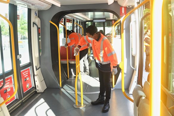 Cleaners disinfect lightrail carriages at Circular Quay.
