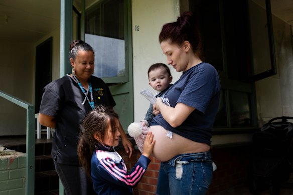 Mel Briggs, visits pregnant mother, Janelle Crump, with two of her eight children, Shakaya, 6, and Amarli, 9 months, at her home in Nowra, NSW.
