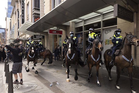 Projectiles including water bottles and flower pots from garden displays on the road are hurled at Mounted Police during a large Anti-lockdown protest in Sydney.