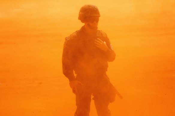 A Brazilian Air Force soldier is covered in dust during the landing of the Brazilian President Jair Bolsonaro's helicopter to the area where the construction of the first Union field hospital is being carried out, in Aguas Lindas de Goias, in the surroundings of Brasilia, Brazil.