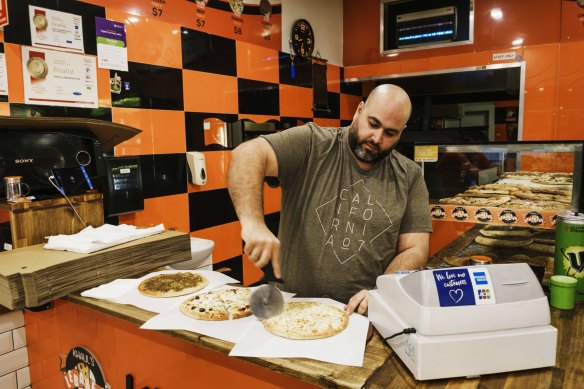 A Manoush style pizza is cut up at the Khalil Lebanese Pizza shop.