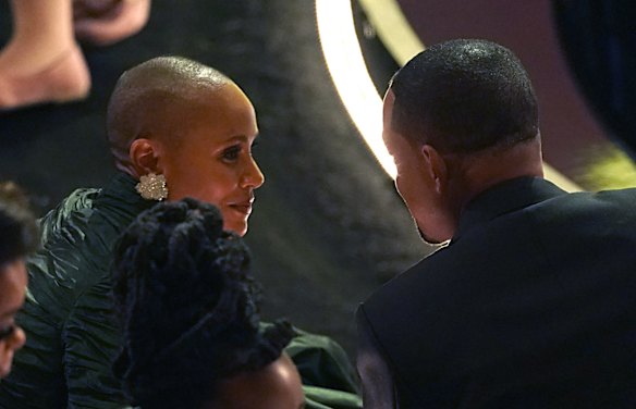 Jada Pinkett Smith, left, has a chat with husband Will Smith after he went on stage and appeared to slap Chris Rock after he made a joke about her.