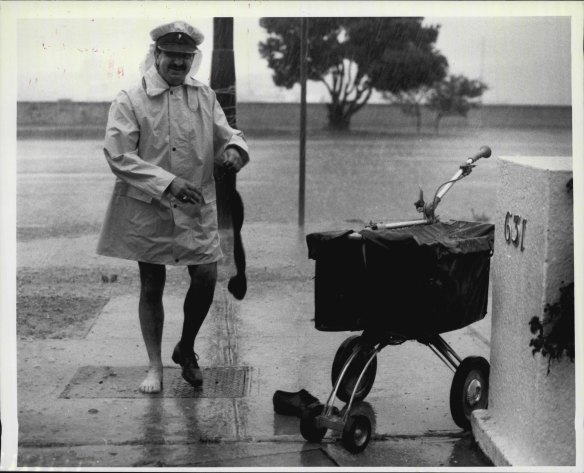 Postman John Tauro is so wet that he decided to take off his shoes and socks while delivering letters in Rose-Bay.