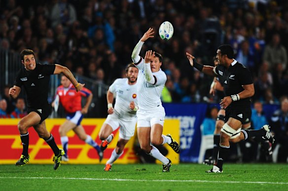 Francois Trinh-Duc of France (C) offloads the ball under pressure.