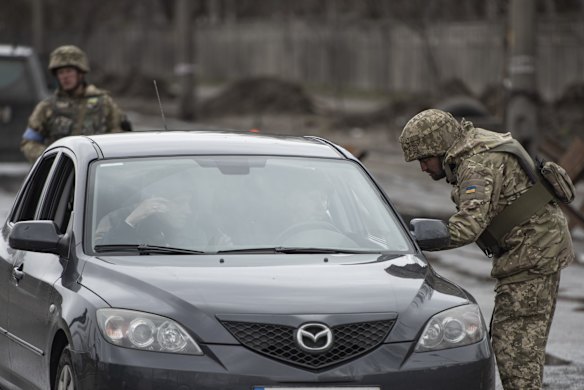 Territorial defence members check cars passing a checkpoint in Kyiv.