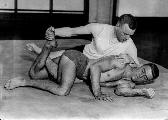 Mr. Charles Hardy keeps fit by wrestling bouts with Jim Deakin, Australian middleweight wresting champion. 