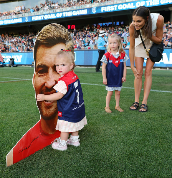 Jack Viney’s daughters take in a picture of his face ahead of his 200th game.
